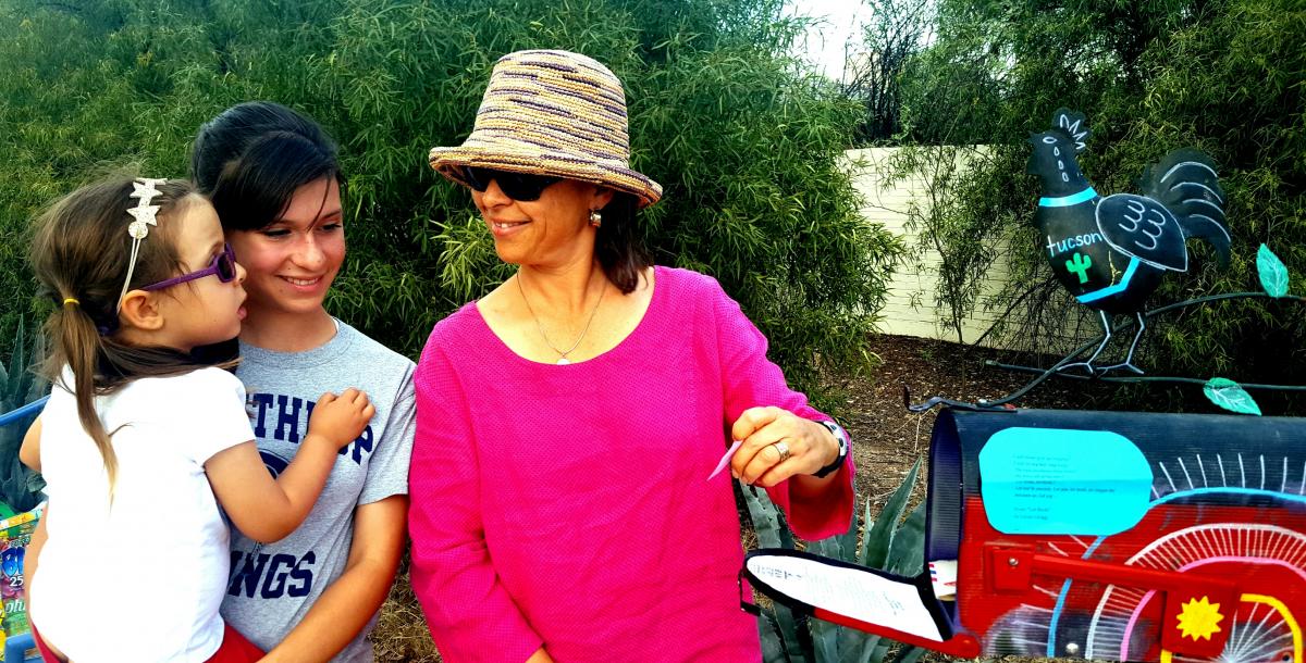 A family visits the Poetry Mailbox to retrieve poems.