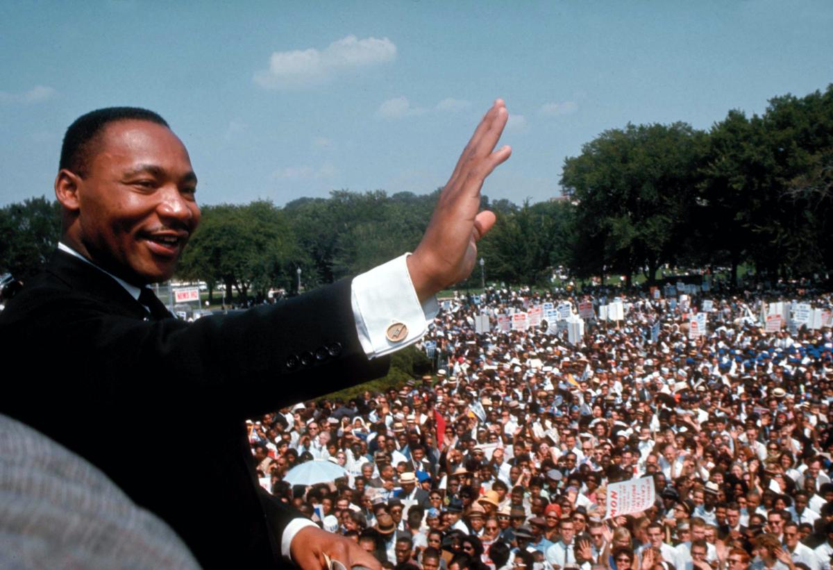 Dr. Martin Luther King Jr holds out one hand to greet the crowd during the March on Washington 