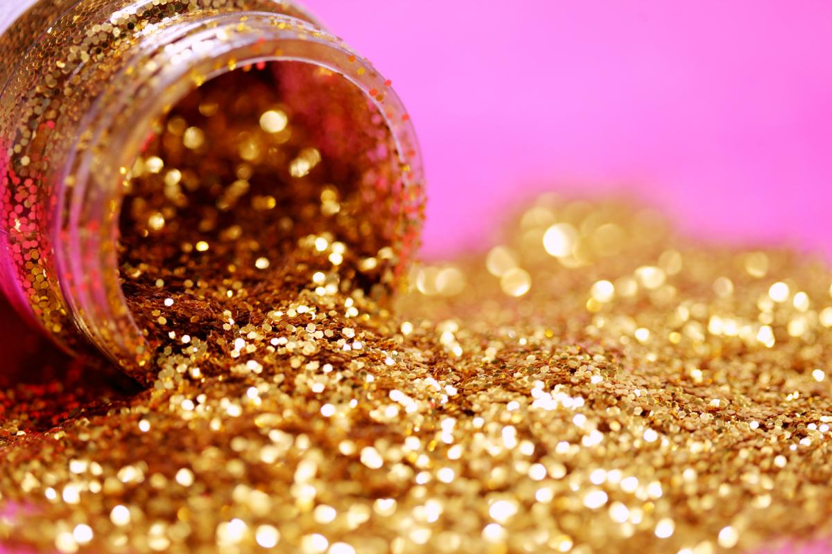 Gold glitter spilled across a pink background / photo by Sharon McCutcheon