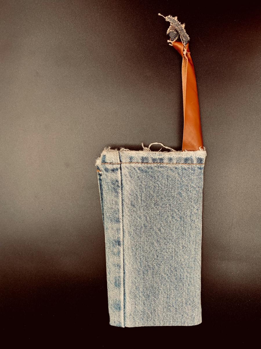 Photo of Totem, a girdle book with a blue-jean cover and leather handle.