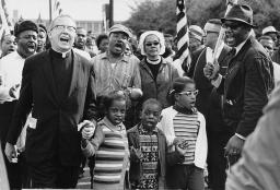 Three small Black children march as part of the Selma to Montgomery March, surrounded by adults