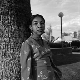 Ai stands in front of a tree in Tucson, in black and white