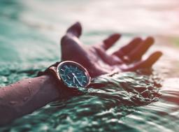 hand in water wearing watch 