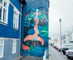 mural of a mermaid on a blue building