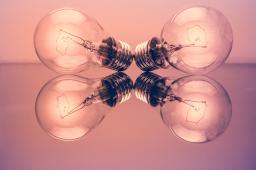 Four lightbulbs against a blush background
