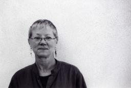 black and white portrait of Linda Gregerson against a white stippled wall