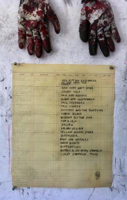 Photo of a poem written on ledger paper, with two work gloves in the top of the frame.