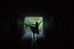 silhouette of a dancer in a tunnel