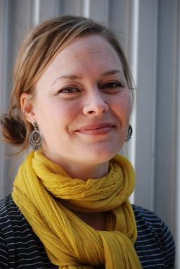 Katherine Larson smiles at the camera, wearing a large yellow scarf