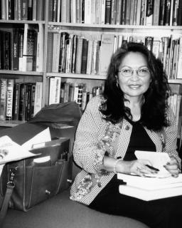 Luci Tapahonso sits in the Poetry Center library, in black and white