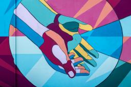 A mural of extended hands in maroon, bright blue, aqua, and yellow.