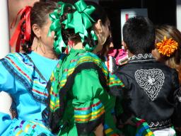Kids with their backs turned to the camera in baile folklorico dress / photo by Delia Wagner