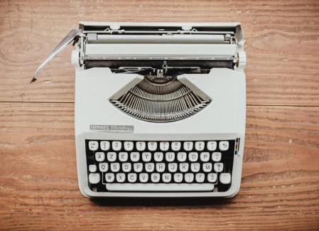 Gray typewriter on a wooden table 