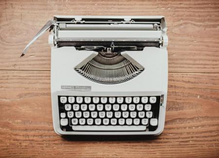 Gray typewriter on a wooden background / photo by Bernard Hermant
