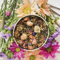 fresh flowers surrounding dried flowers in a tea cup