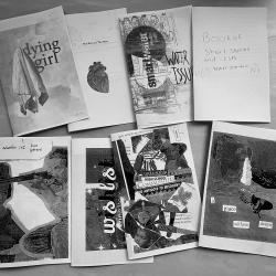A black and white picture showing zines spread out on a table